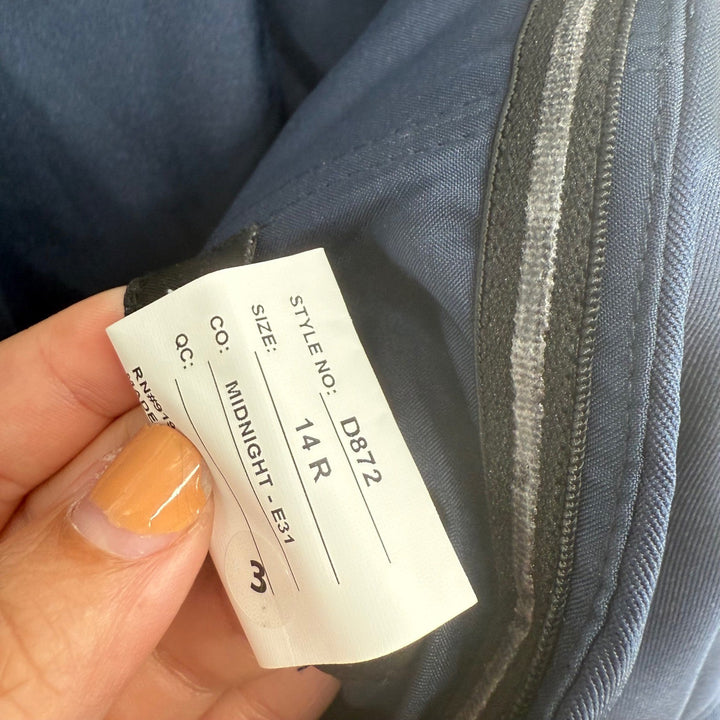 Clothing tag on a blue garment with visible text