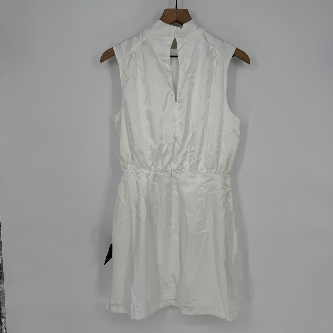 White sleeveless dress on a wooden hanger against a gray background
