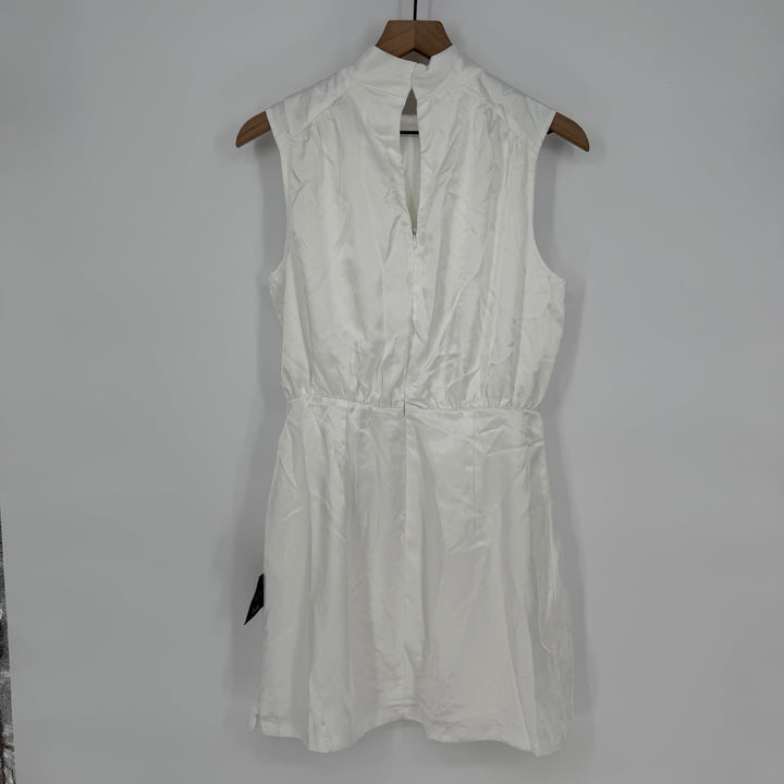 White sleeveless dress on a wooden hanger against a gray background
