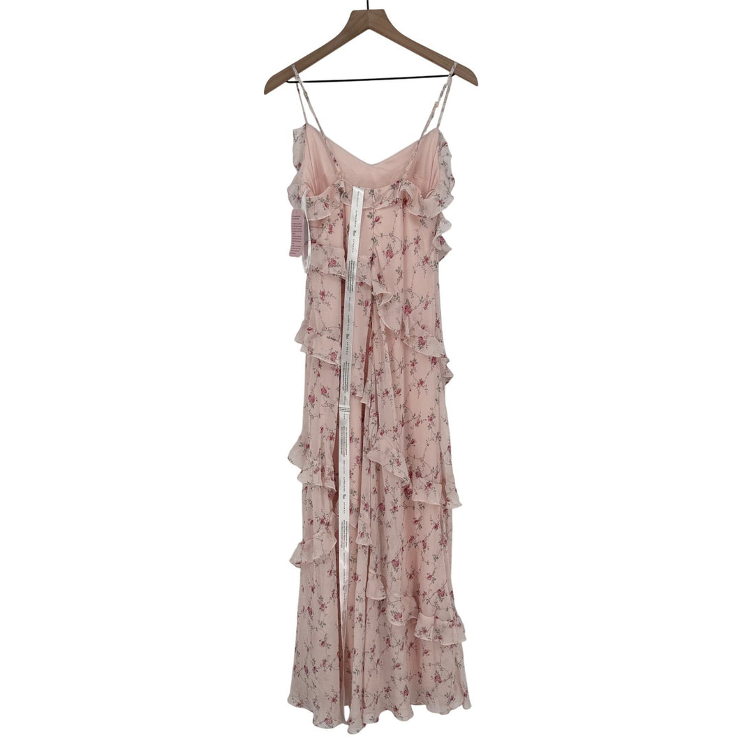 Pink floral dress on a hanger against a white background