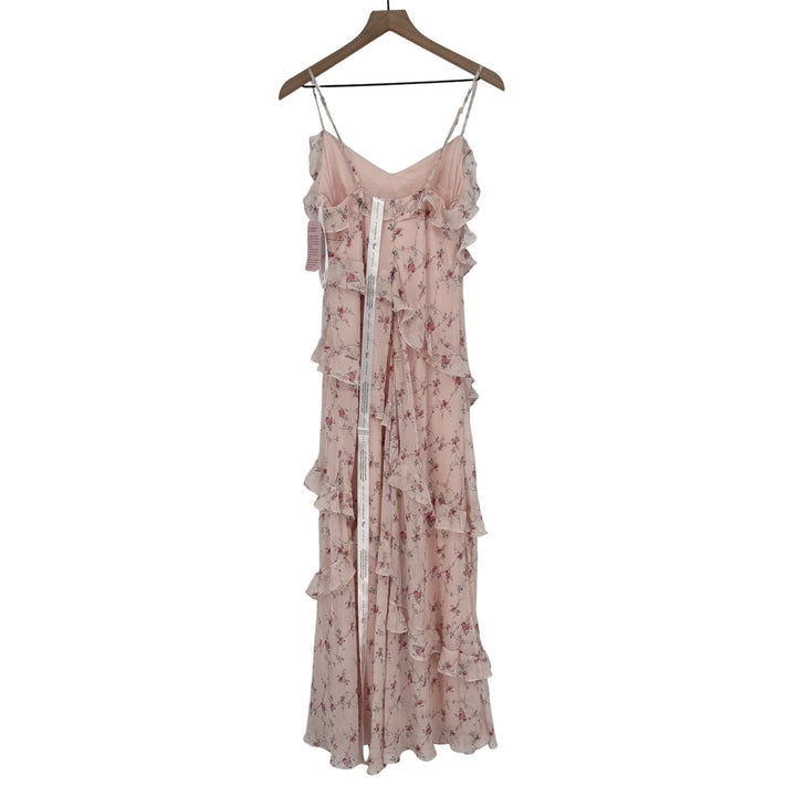 Pink floral dress on a hanger against a white background