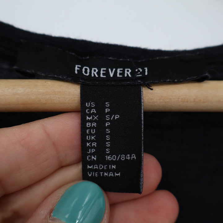 Clothing label with 'Forever 21' branding held by a hand.
