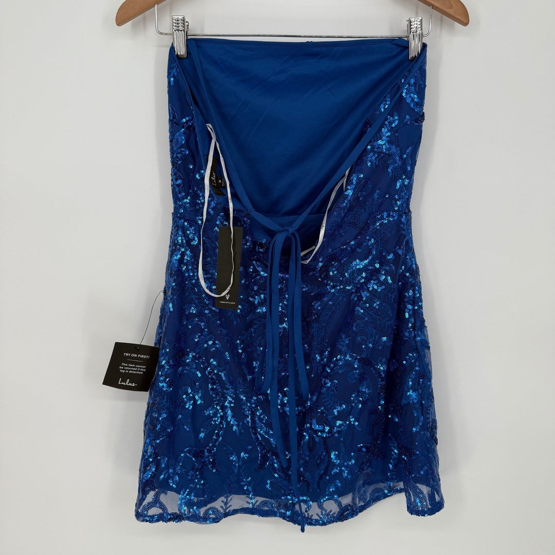 Blue sequin dress on a hanger against a white background