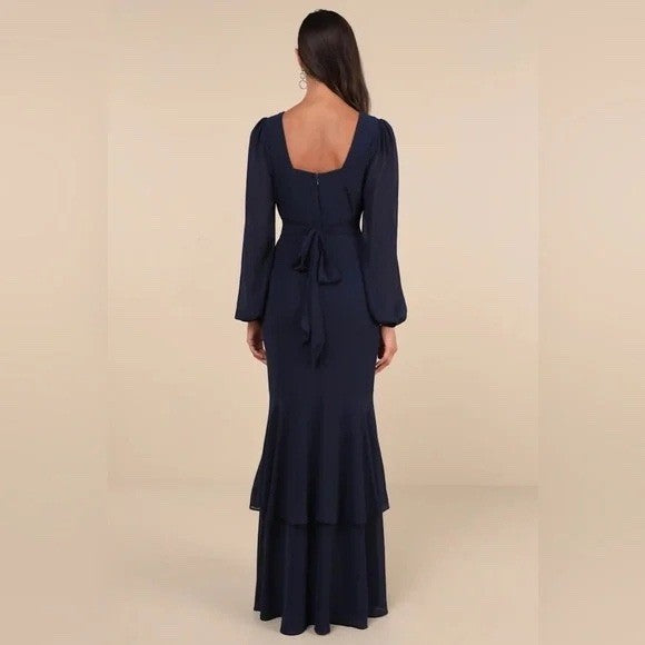 Navy blue long-sleeve dress with a layered skirt on a beige background