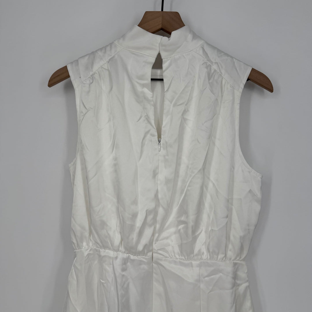 White sleeveless dress on a wooden hanger against a plain background