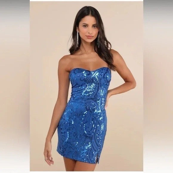 Woman wearing a blue sequin strapless dress on a beige background