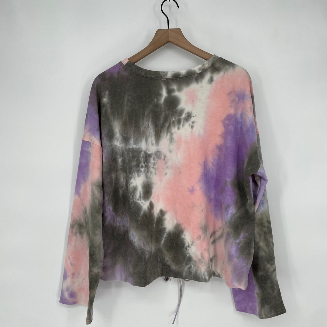 Tie-dye long-sleeve shirt on a hanger against a white background