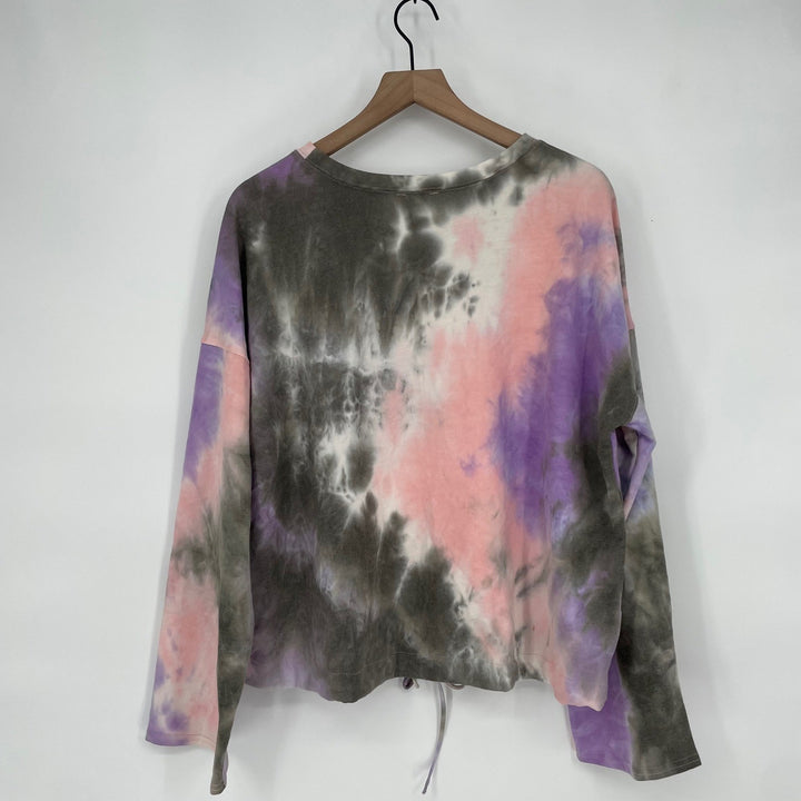 Tie-dye long-sleeve shirt on a hanger against a white background