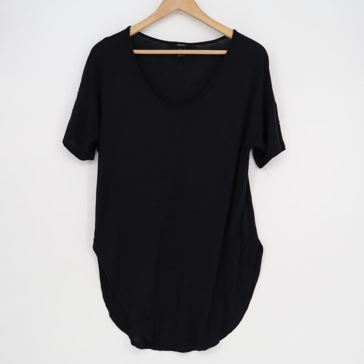 Black t-shirt on a wooden hanger against a white background