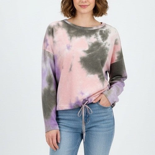 Person wearing a tie-dye sweatshirt and jeans on a white background