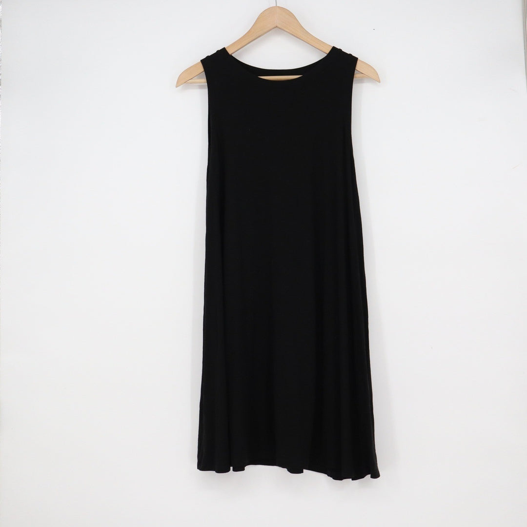 Black sleeveless dress on a wooden hanger against a white background