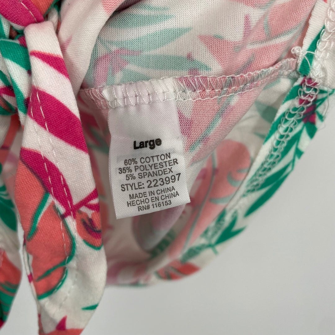 Close-up of a fabric label on a floral-patterned garment with visible text.