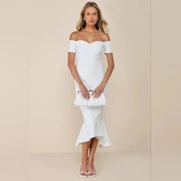 Woman wearing a white off-shoulder dress against a beige background