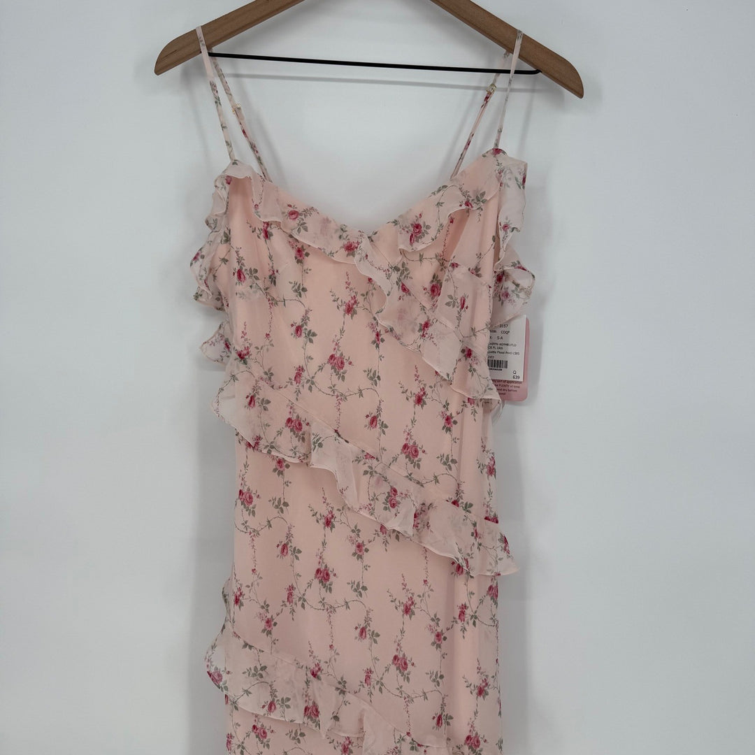 Pink floral dress on a hanger against a white background