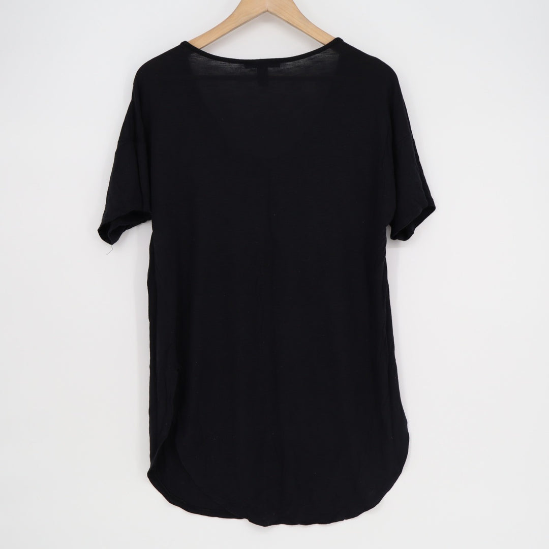 Black t-shirt on a wooden hanger against a white background