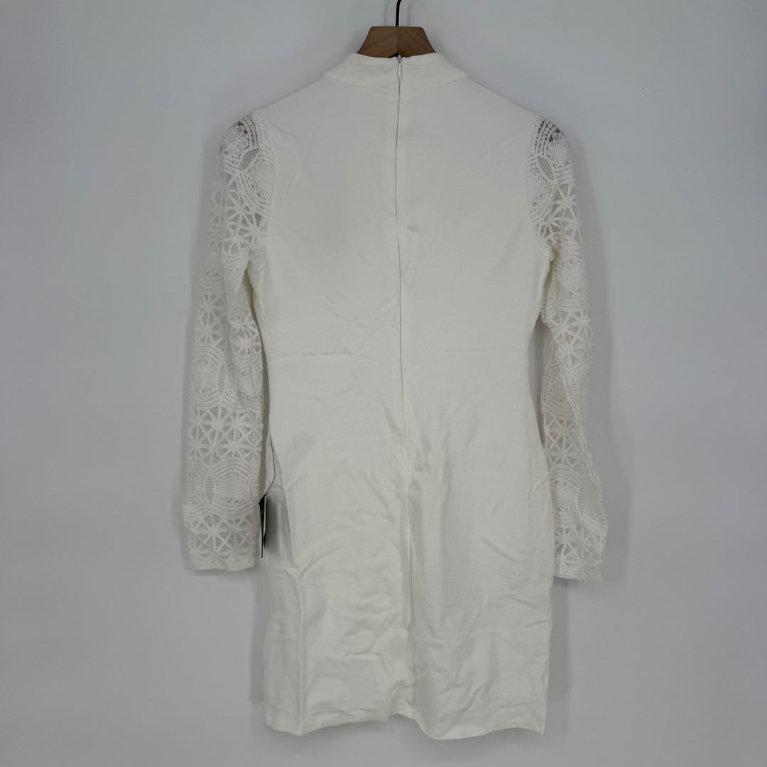 White lace-trimmed dress on a mannequin against a plain background