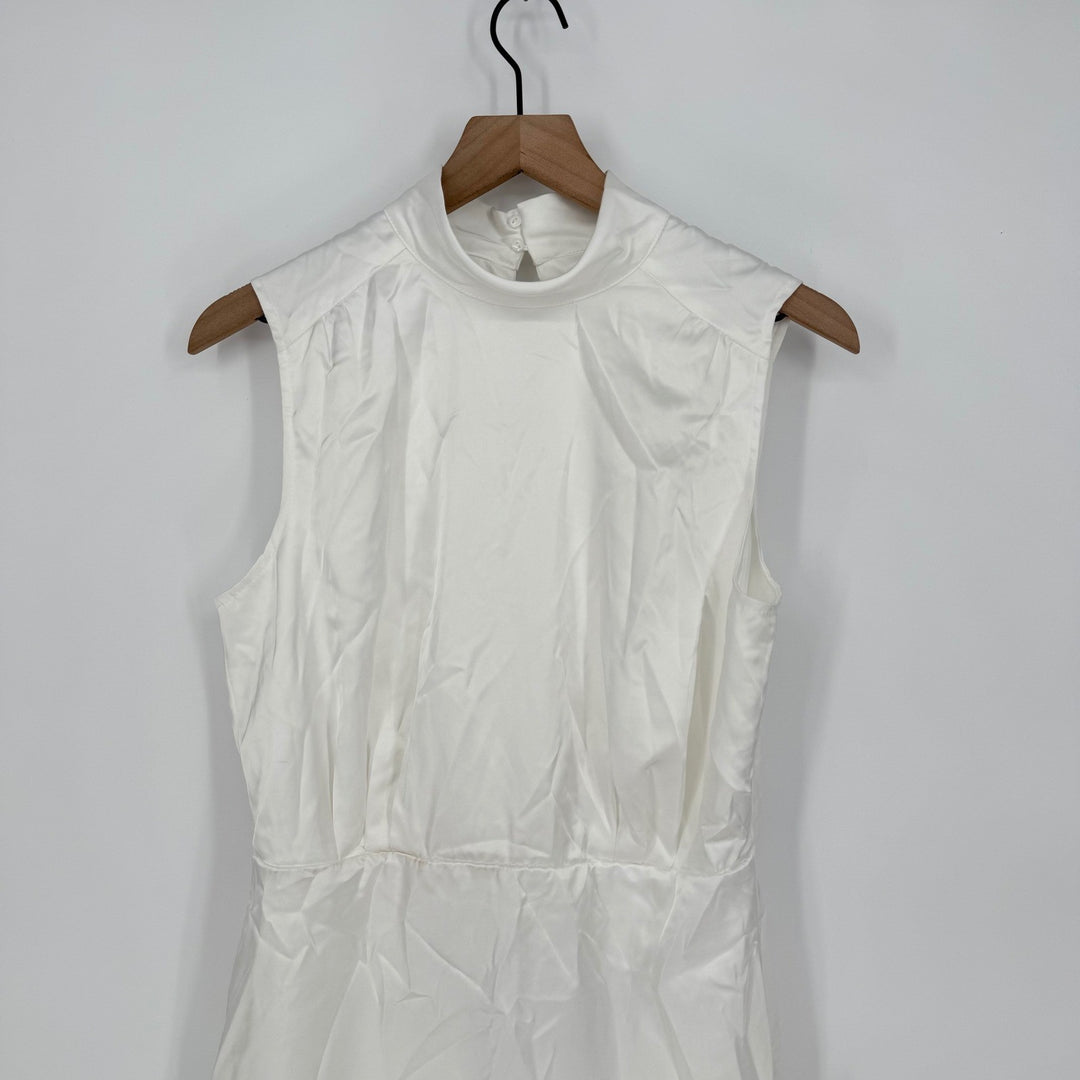 White sleeveless dress on a wooden hanger against a white background
