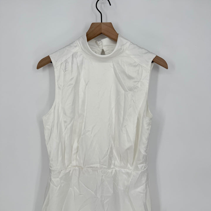 White sleeveless dress on a wooden hanger against a white background