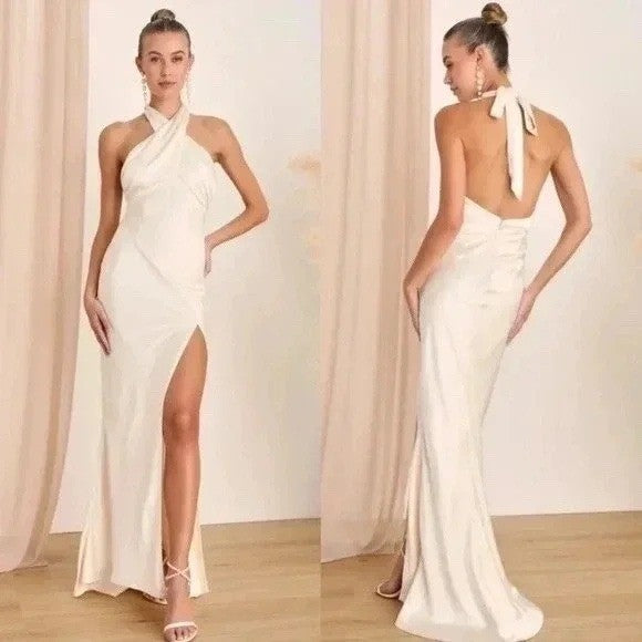 White evening gown with a high slit and open back worn by a model against a neutral background.