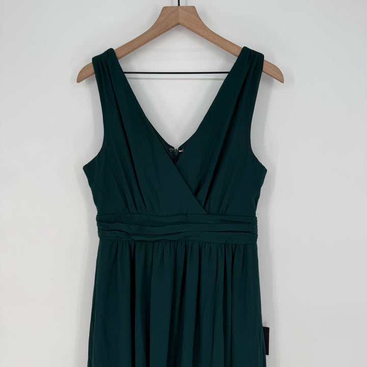 Green dress on a wooden hanger against a white background