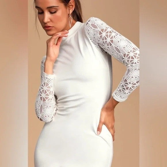 Woman wearing a white dress with lace sleeves against a beige background