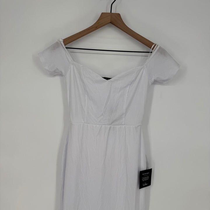 White dress on a wooden hanger against a white background