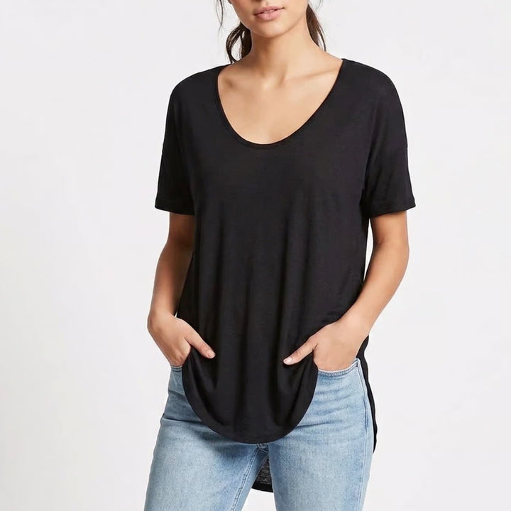 Person wearing a black t-shirt and light blue jeans on a white background