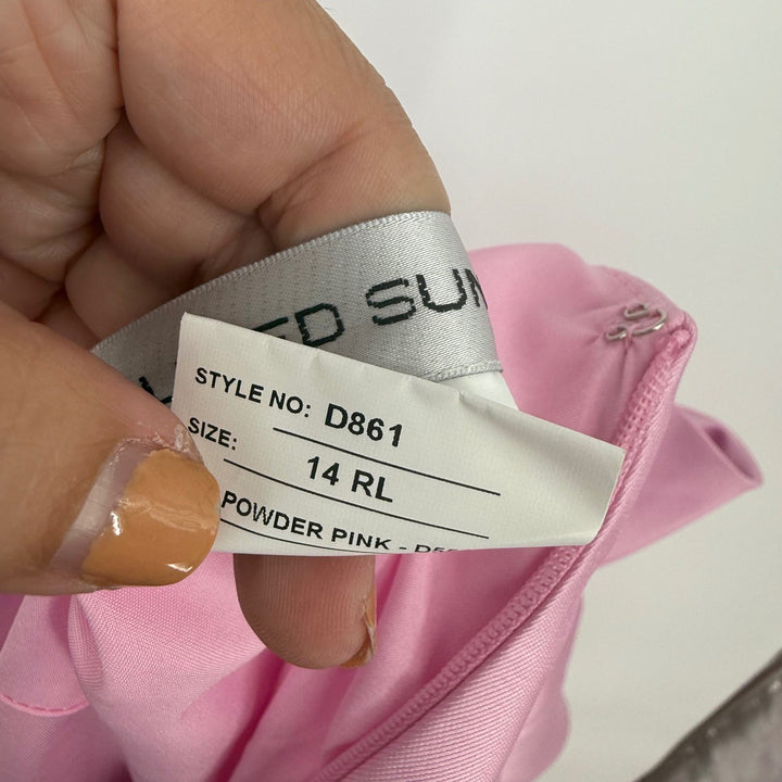 Close-up of a clothing tag on a pink garment with 'Dundie' branding.