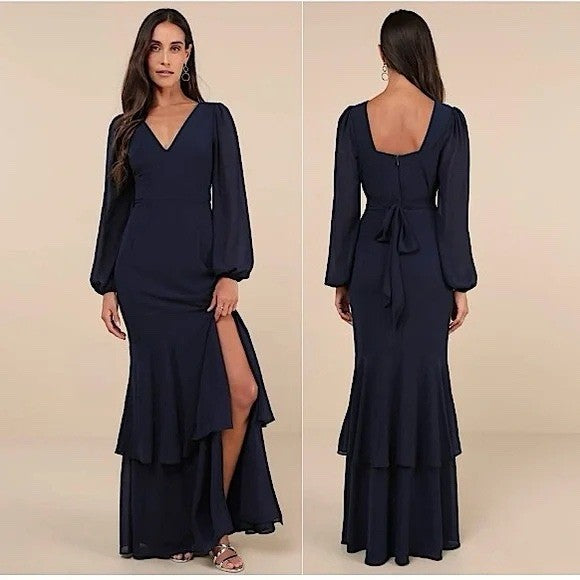 Navy blue evening gown with long sleeves and a slit on a beige background