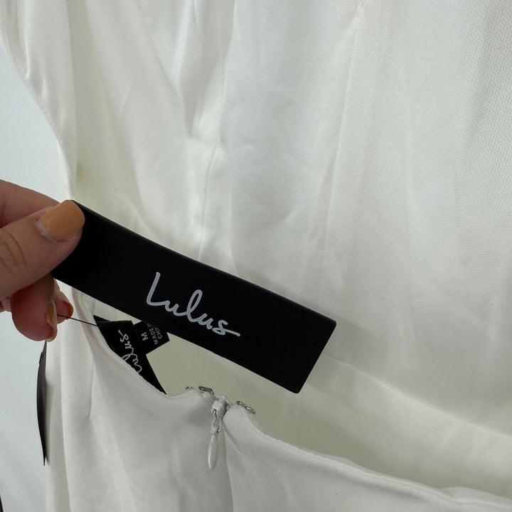 Close-up of a Lulus tag on a white garment with a light gray background