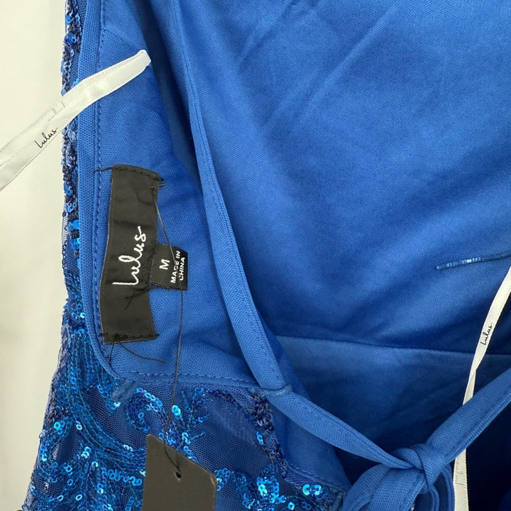 Close-up of a blue dress with a label and tag on a white background