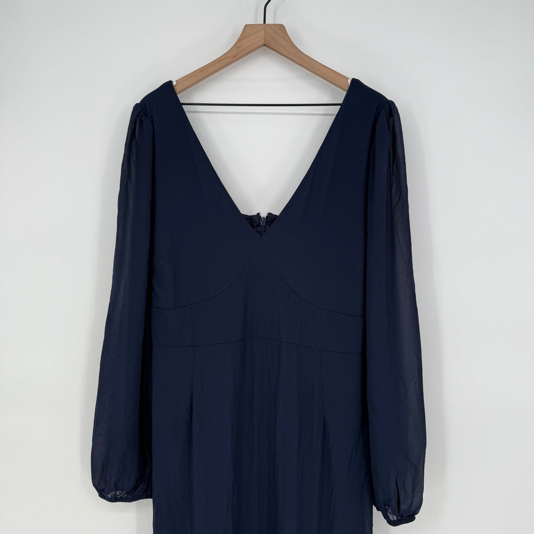 Navy blue dress on a wooden hanger against a white background