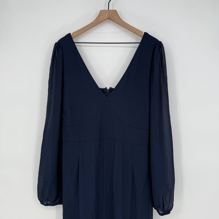 Navy blue dress on a wooden hanger against a white background