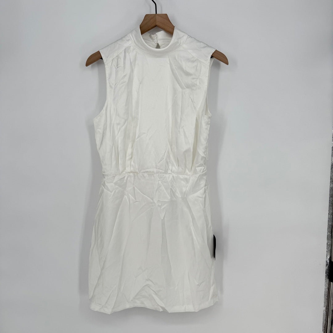 White sleeveless dress on a wooden hanger against a plain background