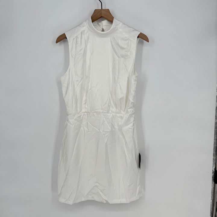 White sleeveless dress on a wooden hanger against a plain background