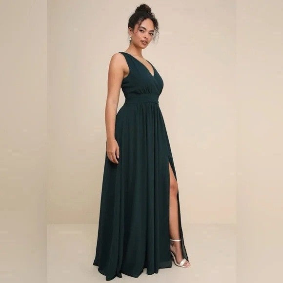 Woman wearing a dark green evening gown with a slit on a beige background